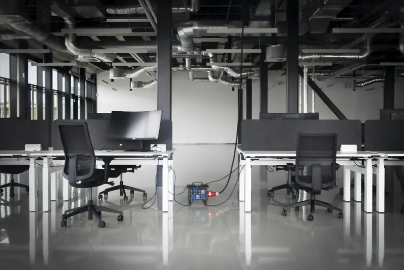 Open plan office with exposed services and bench desks